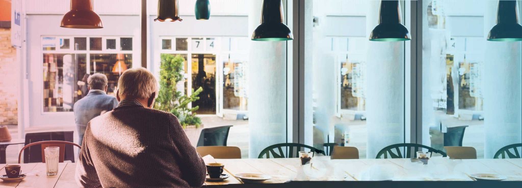 A man looking out the window while having coffee