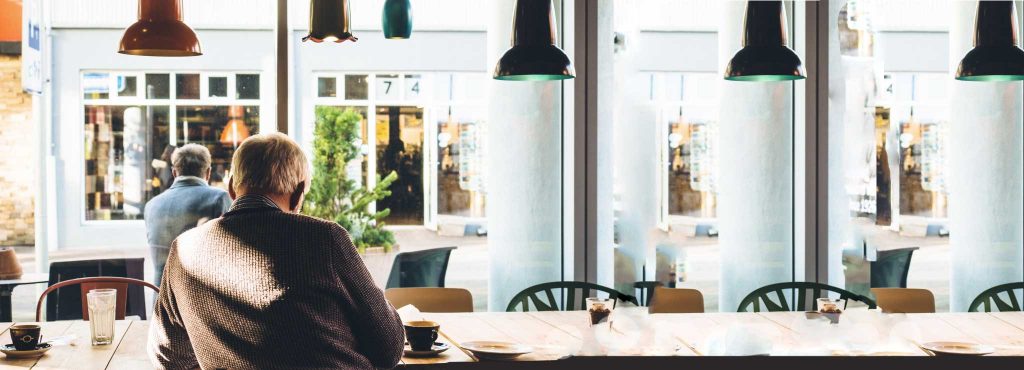 An older man sitting in a cafe